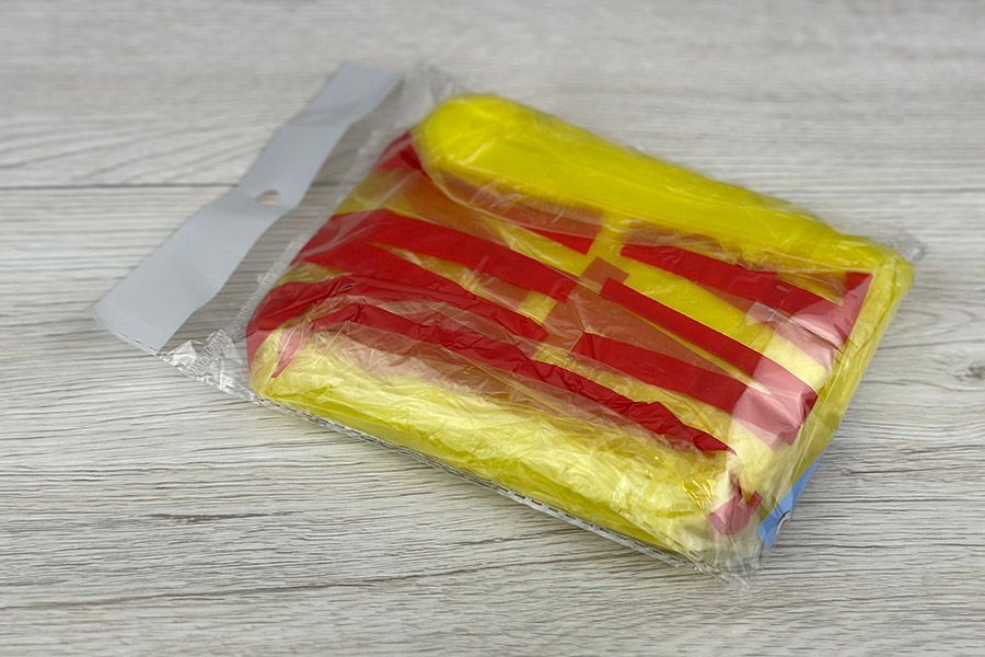 gele poncho met bedrukte logo in polybag verpakt